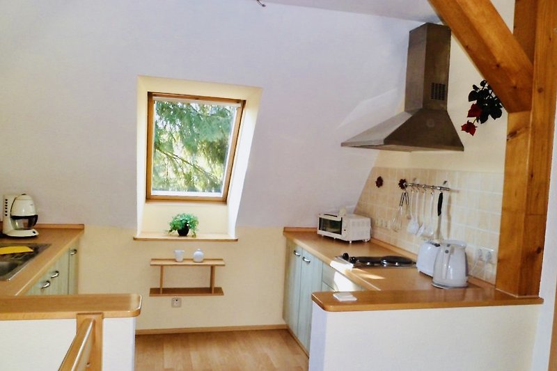 Moderne Küche mit Holzakzenten und Fensterblick. Wohnung 2