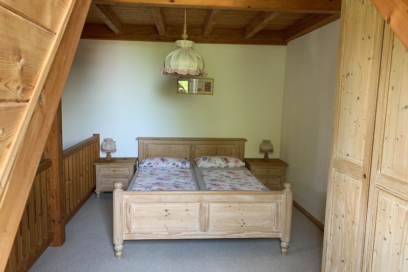 Gemütliches Schlafzimmer mit Holzmöbeln und Fenster.
