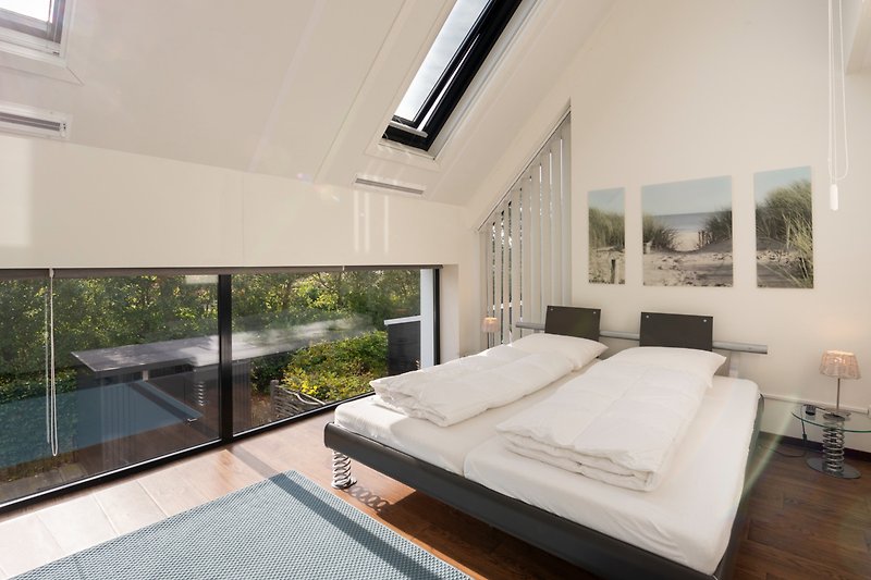 Gemütliches Schlafzimmer mit Holzbett, stilvollem Interieur und Fensterbehandlung.