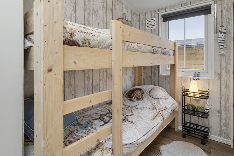 Holzbett mit Etagenbett und Bettwäsche. Gemütliches Schlafzimmer.