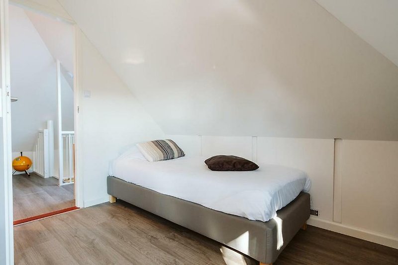 Stilvolles Schlafzimmer mit gemütlichem Bett und stilvoller Beleuchtung.