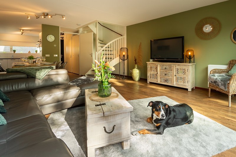 Stilvolles Wohnzimmer mit Holzboden, bequemer Couch und stilvoller Einrichtung.