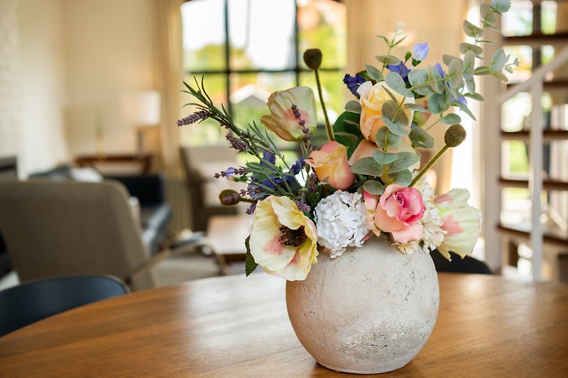 Blumige Tischdekoration mit stilvollen Vasen.