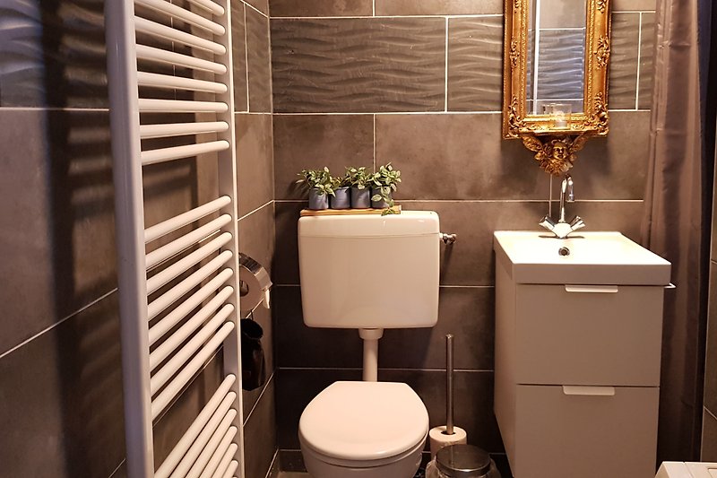Stilvolles Badezimmer mit moderner Beleuchtung und Keramikfliesen.