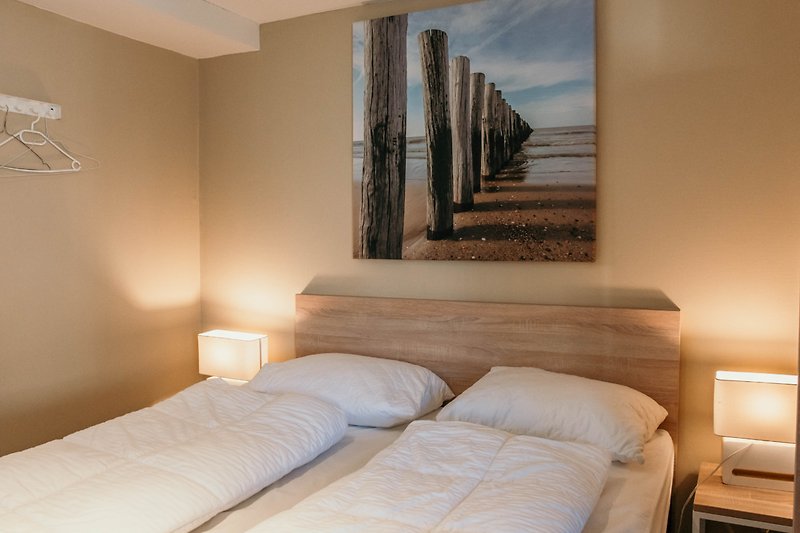 Stilvolles Interieur mit Holzmöbeln und gemütlichem Bett.