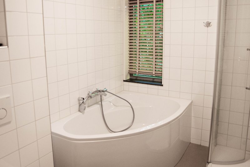 Modernes Badezimmer mit Badewanne, Dusche und stilvoller Einrichtung.