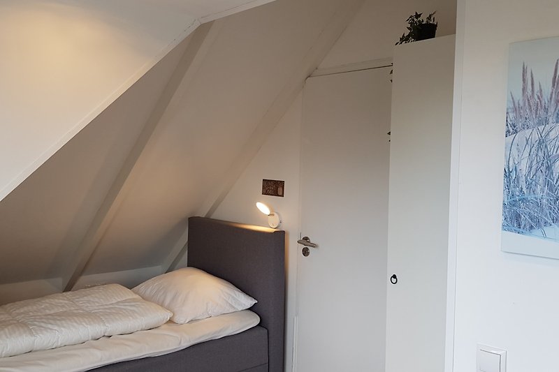 Stilvolles Schlafzimmer mit elegantem Bett und Kunst an der Wand.