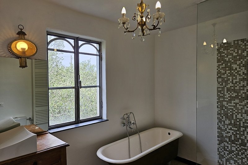 Modernes Badezimmer mit Badewanne, Armaturen und Fenster.