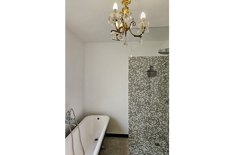 Modernes Badezimmer mit Metallarmaturen und Keramikwaschbecken.