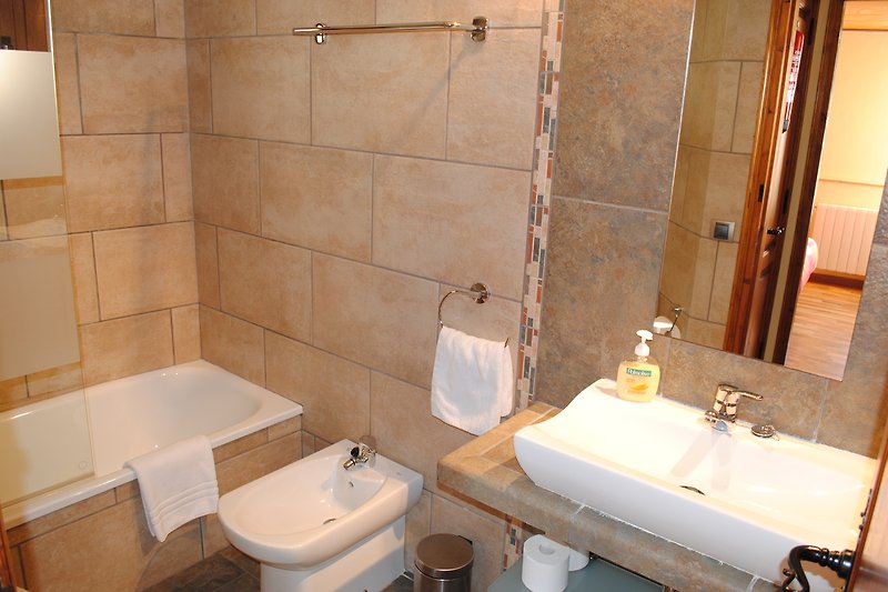 Hermoso baño con lavabo de cerámica, espejo y accesorios morados.