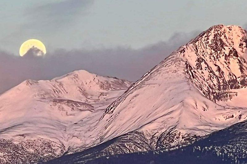 Beeindruckende Berglandschaft mit Schnee, Mondlicht und majestätischen Gipfeln.