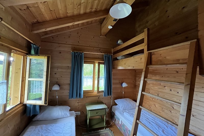 Gemütliches Schlafzimmer mit Holzbett und gemütlicher Bettwäsche.