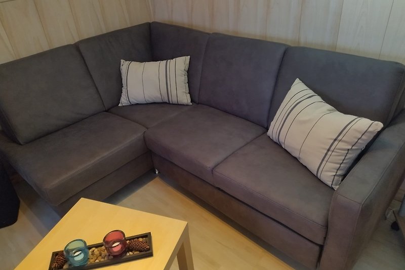 Wohnzimmer mit Couch, Kamin, Esstisch und Fernseher