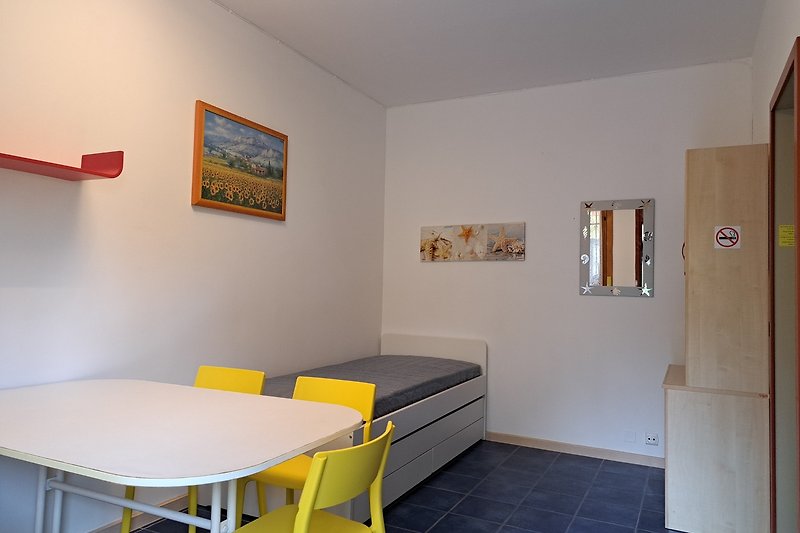 Gemütliche Einrichtung mit Holzboden und Kunst an der Wand. Bequeme Möbel und gemütlicher Tisch.