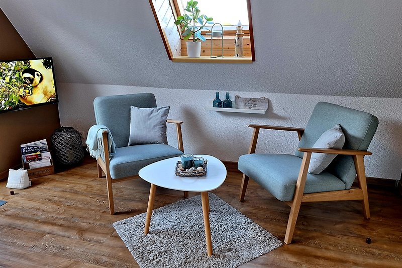 Helles Wohnzimmer mit Holzdetails, Couch, Pflanzen und großem Fenster.