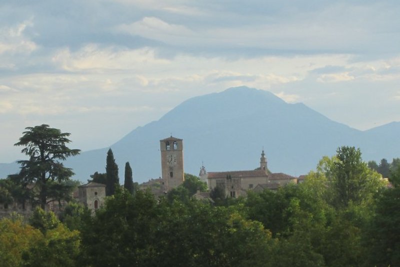 Das mittelalterliche Dorf Castellaro Lagusello, im Hintergrund der Monte Baldo (2230 m).