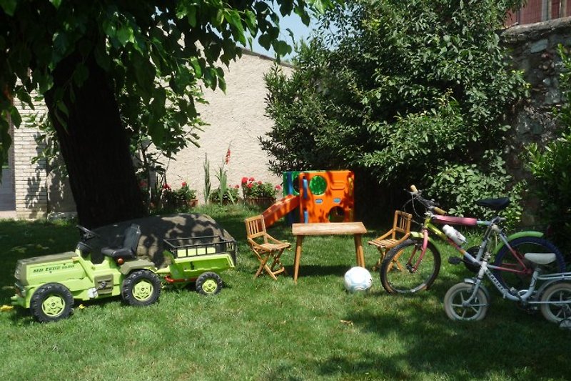 Die Kinderspiele: Fahrräder, Traktor, Kletterwürfel,Tisch mit Stühlchen.