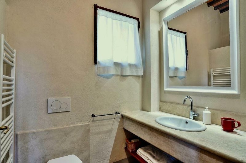 Un bagno moderno con specchio, rubinetto e lavabo in ceramica.