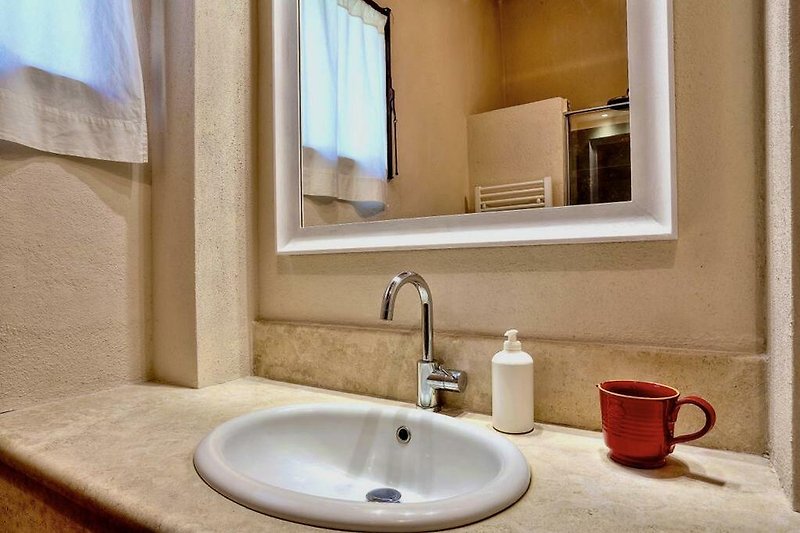 Un bagno moderno con specchio, rubinetto e lavabo in ceramica.