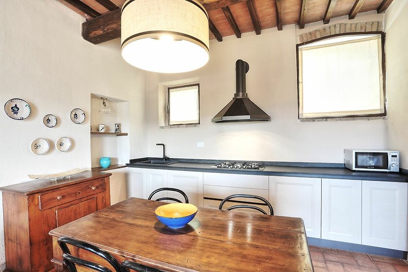 Cucina in legno con illuminazione, mobili e piano in legno, armadietto e luce sopra il tavolo.