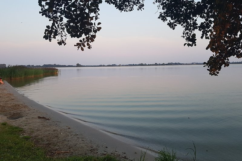 Abendstimmung am See mit Spiegelung im ruhigen Wasser.