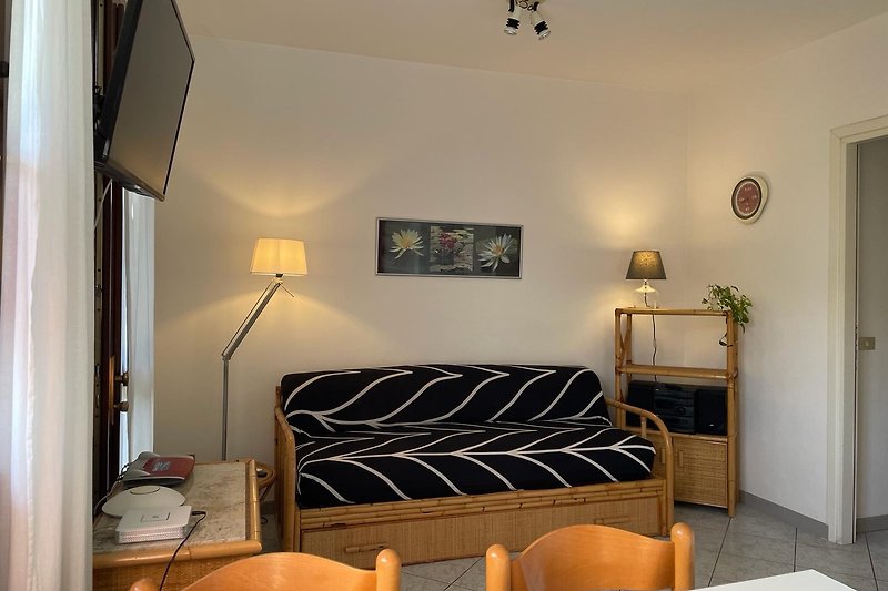 Stilvolles Wohnzimmer mit bequemer Couch, elegantem Lampendesign und gemütlichen Kissen.