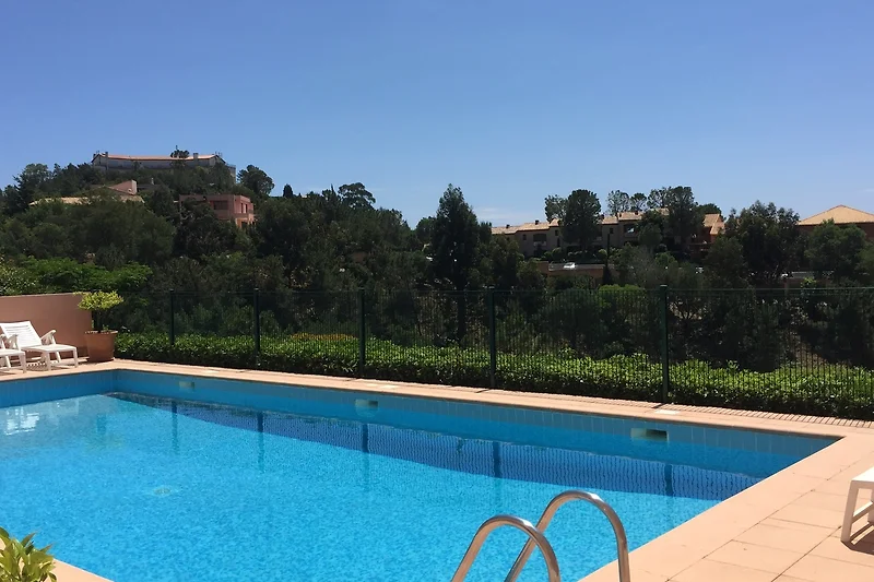 Zwembad en groen landschap in een resort-stad.