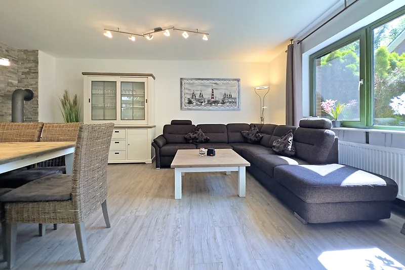 Offener Wohnbereich mit Sofa, Sessel, Couchtisch und TV-Gerät. Haus 30 A