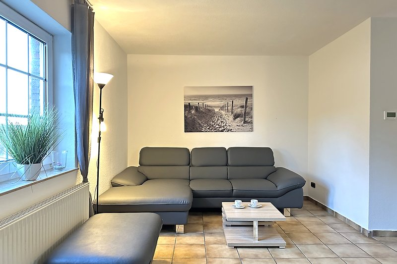 Gemütliches Wohnzimmer mit Holzboden, bequemer Couch und stilvoller Einrichtung.