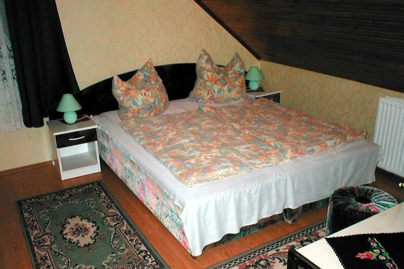 Gemütliches Schlafzimmer mit stilvollem Holzbett und bequemen Kissen.