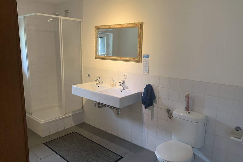Ein lila Badezimmer mit stilvoller Beleuchtung und modernem Waschbecken.