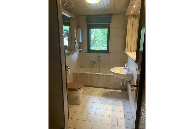 Ein stilvolles Badezimmer mit Spiegel, Fenster und Waschbecken.