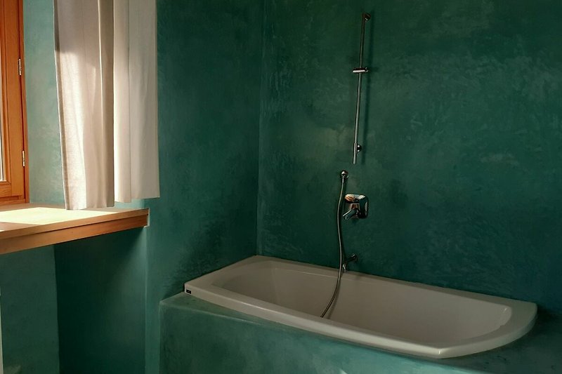 Elegantes Badezimmer mit Badewanne, Dusche und modernem Design.