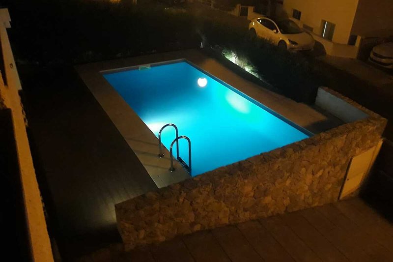 Eleganter Poolbereich mit modernem Design und Blick aufs Wasser.