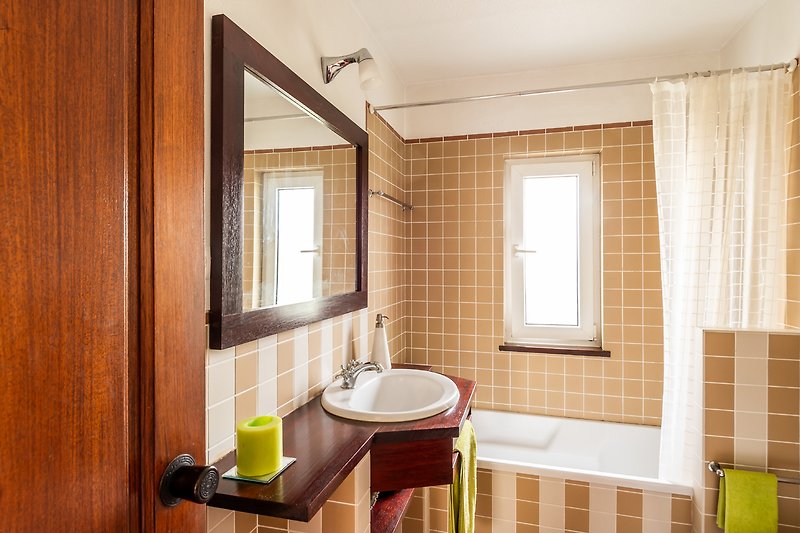 Elegantes Badezimmer mit Holzelementen und Badewanne.