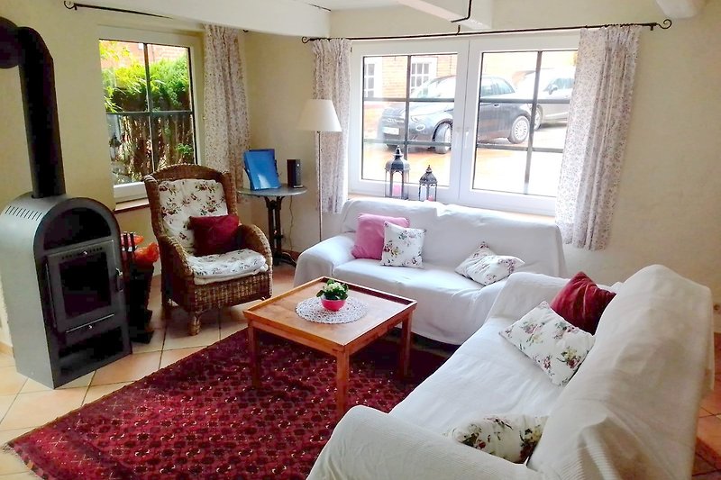 Wohnzimmer mit bequemer Couch, Tisch und Kaminofen