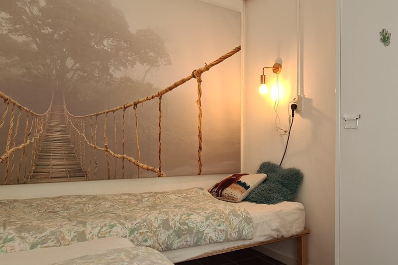 Stilvolles Schlafzimmer mit Holzbett, hochwertigen Textilien und gemütlicher Beleuchtung.