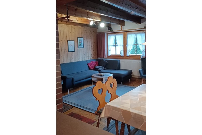 Haus B gemütliche Inneneinrichtung mit Holzmöbeln und bequemer Couch.
