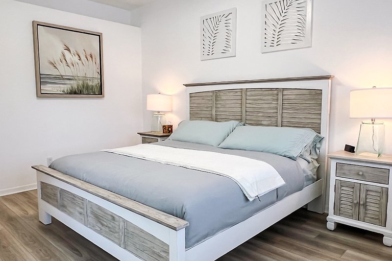 Schlafzimmer mit bequemem Bett, stilvoller Beleuchtung und Holzmöbeln.