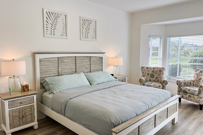 Stilvolles Schlafzimmer mit gemütlichem Bett, Holzmöbeln und dekorativer Beleuchtung.