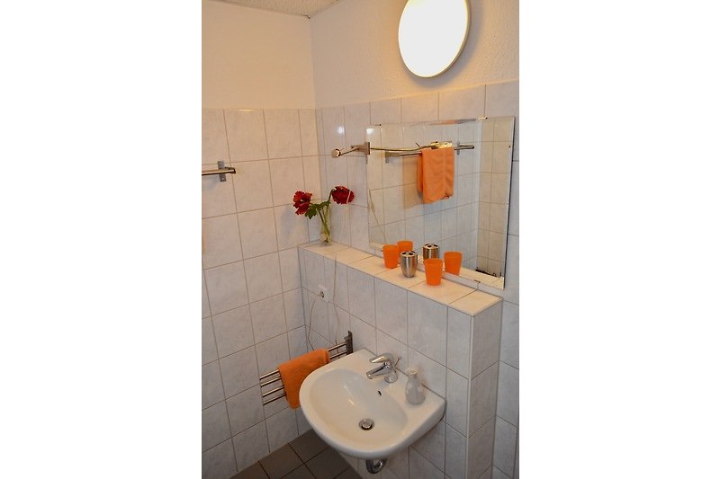 Badezimmer mit Waschbecken und Spiegel.