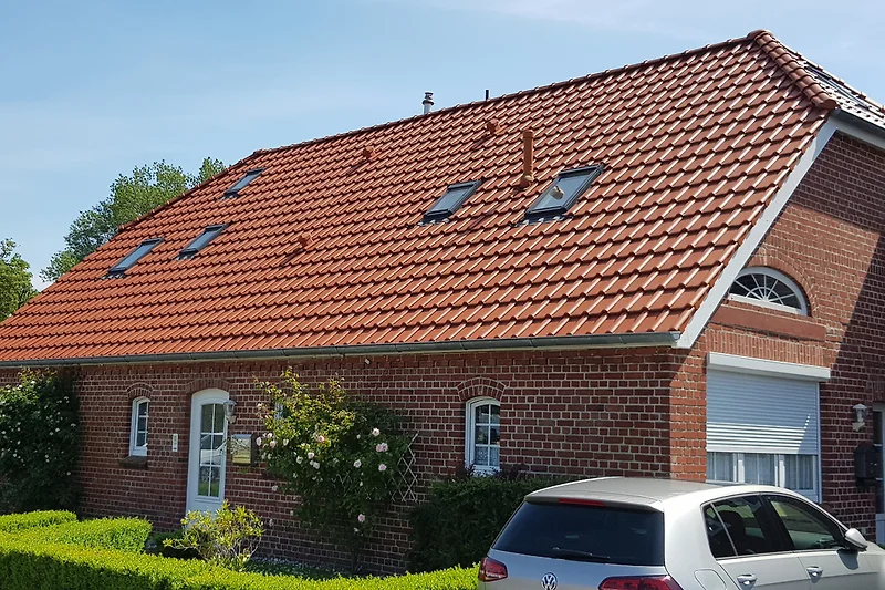 Links der Eingang zur Fewo im OG, rechts die Parkplätze.