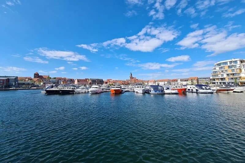 Boot am ruhigen Wasser im Hafen, umgeben von Yachten und Docks.