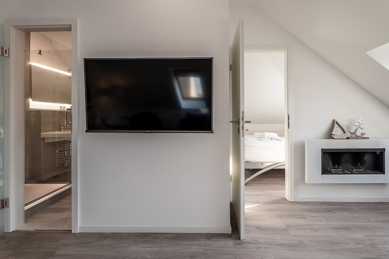 Modernes Wohnzimmer mit Fernseher und Holzregalen.