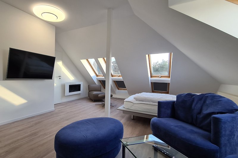Wohnzimmer mit Doppelbett und Biokamin
