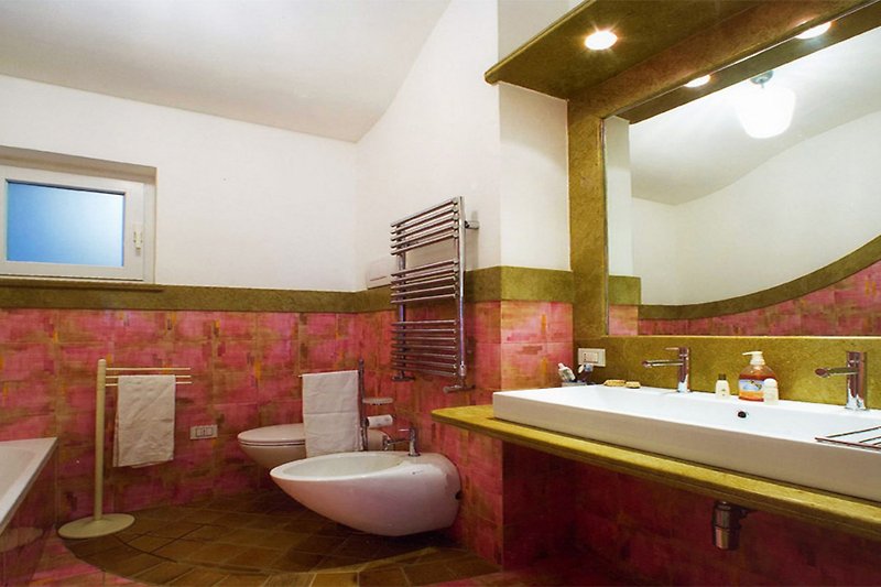 Badezimmer mit lila Akzenten und Spiegel.