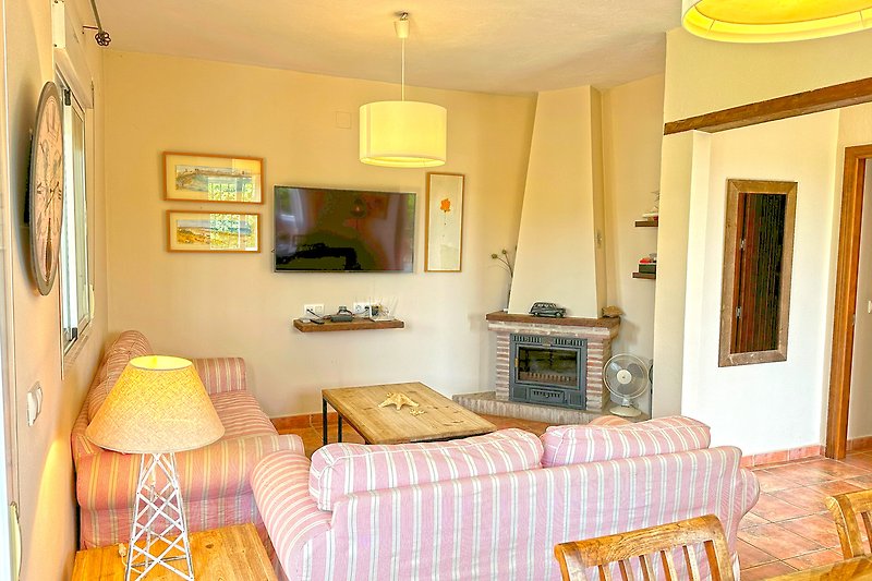 Una sala de estar luminosa y acogedora con muebles elegantes y una decoración en tonos amarillos y madera.