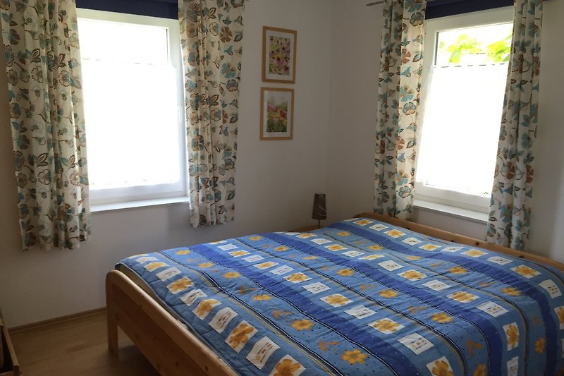 Gemütliches Schlafzimmer mit Holzmöbeln und blauen Akzenten. im Erdgeschoss