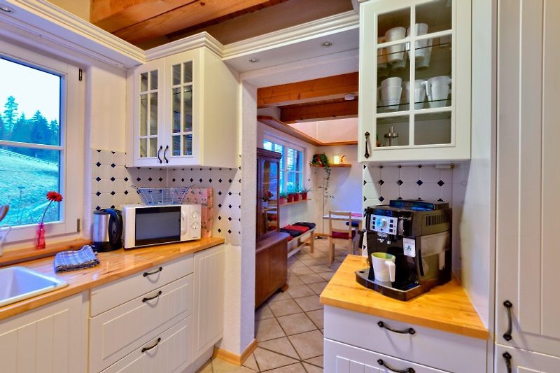Küche mit Kaffeevollautomatik und Blick in den Wohnbereich
