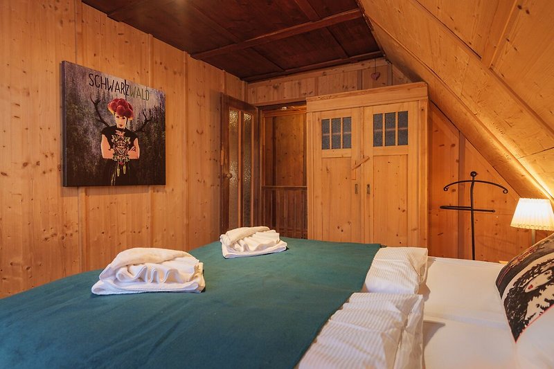 Schönes Schlafzimmer mit Holzbett, Kunst und stilvollem Interieur.